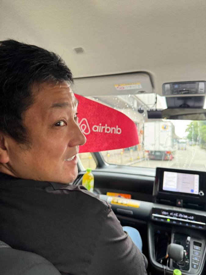 車内で旗を持ち笑う男性の横顔
