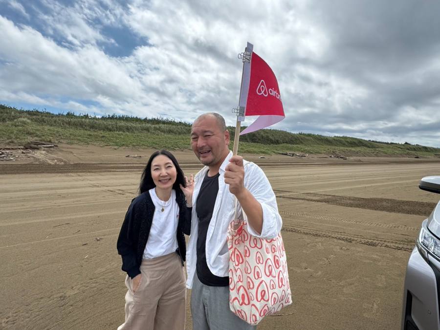 砂浜で寄り添う2人の記念写真