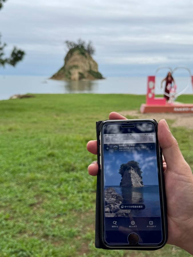 スマホで見附島の写真を見比べる