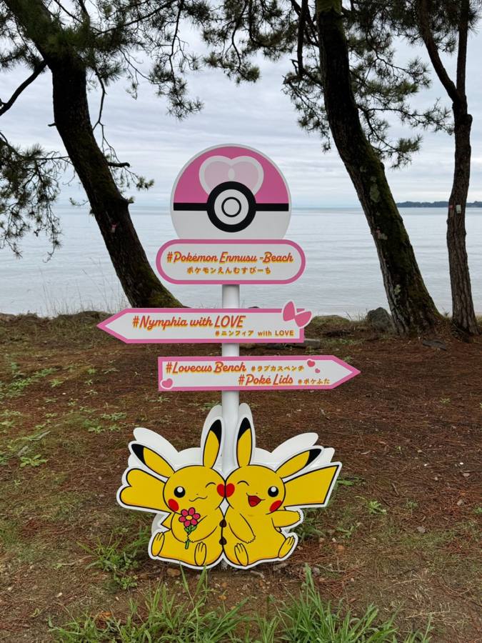 ピカチュウの案内標識と海辺の松並木