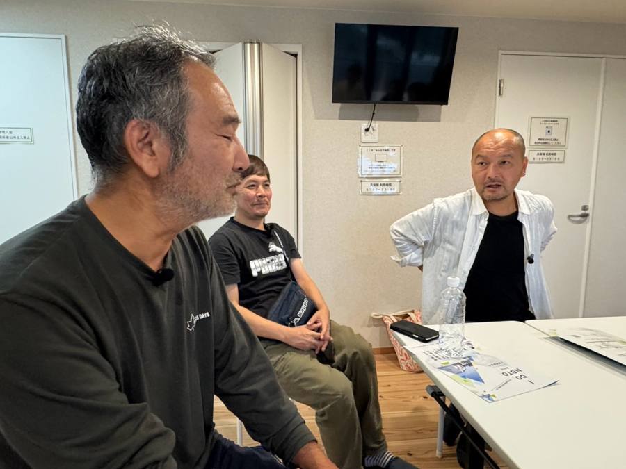 会議室で3人が向き合って話す