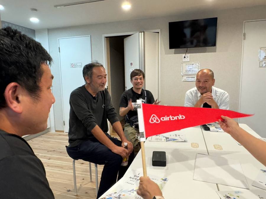会議室でAirbnb旗を掲げる4人