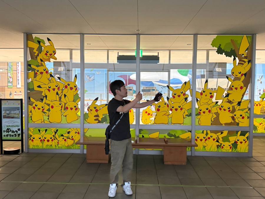 ピカチュウの壁画を撮影する男性