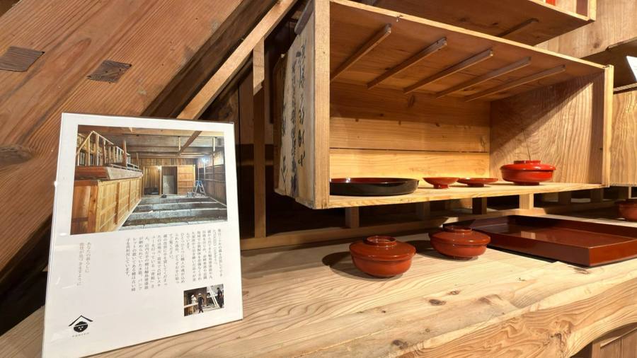 輪島塗の解説パネルと朱色の器