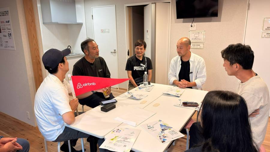 Airbnbの旗を手に話し合う様子