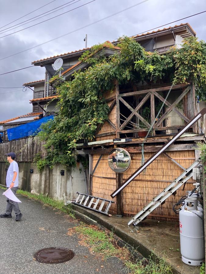 老朽化した建物の脇を通る