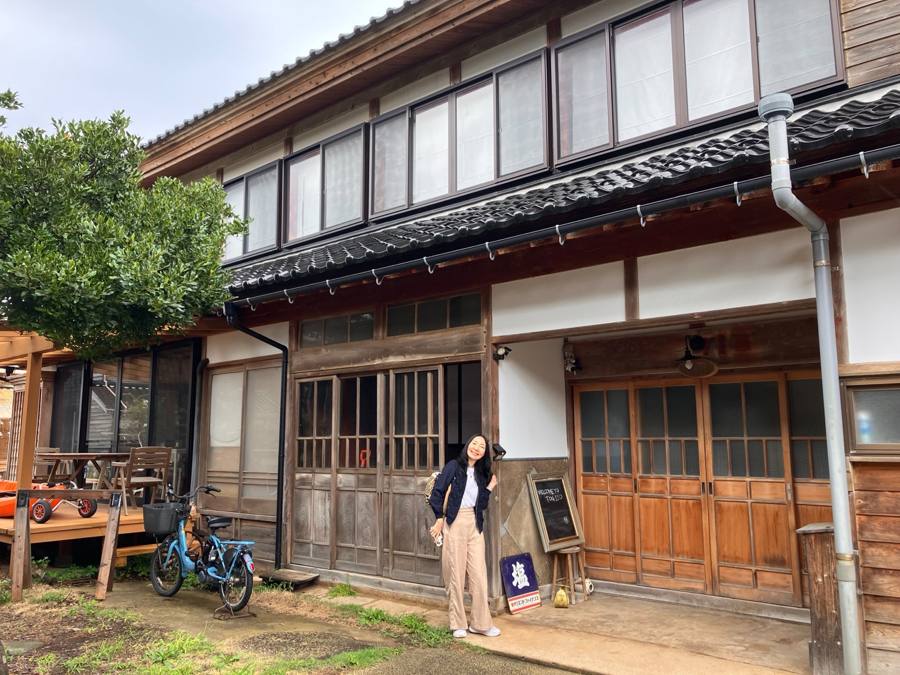 古民家の玄関前で微笑む